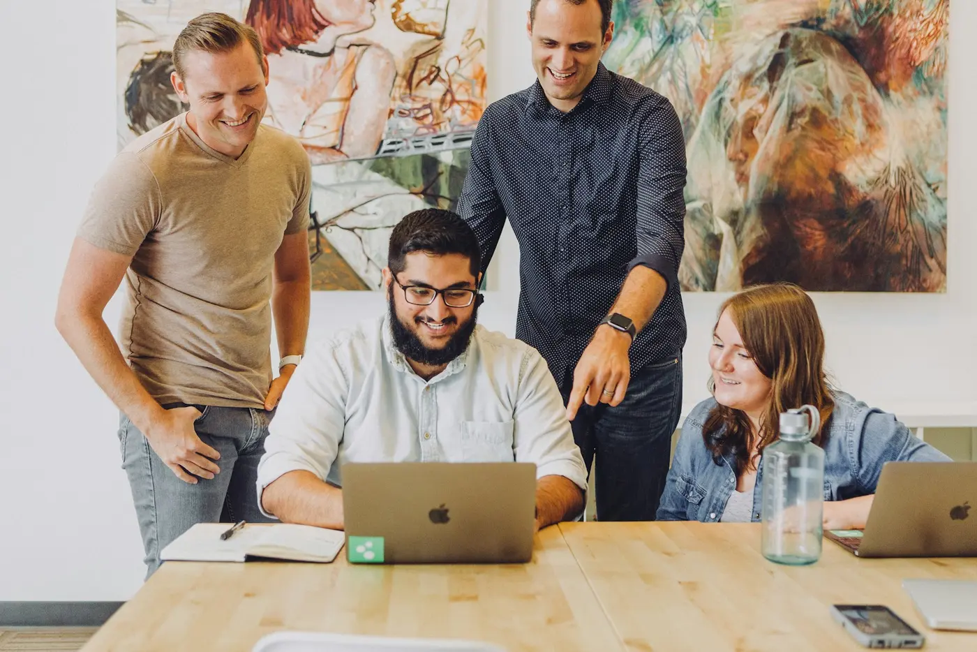 A small product team reviewing work together on a laptop